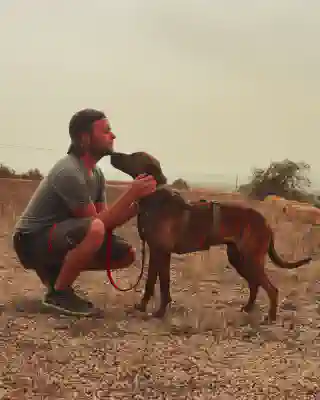 Georg bekommt ein Küschen von Philomeno, einem Jagdhund-Mischling.