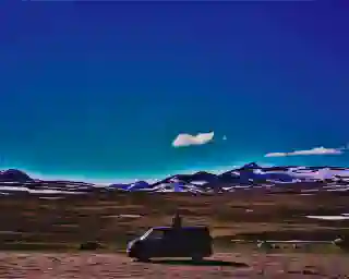 Georg sits on the Quest at Vildmarksvägen.
In the foreground the Quest in the desert, in the background a picturesque image of mountain peaks.
