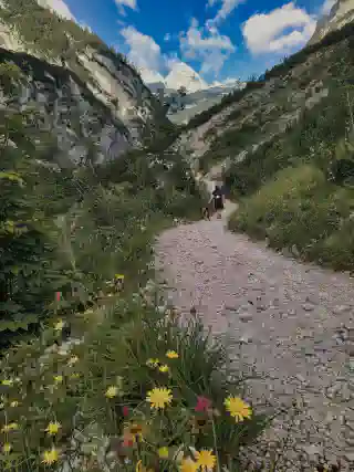 Der Weg Rechts und links die Berge. Georg und Momo in der Mitte auf dem Weg.