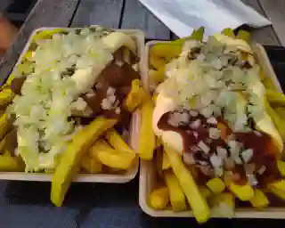 Zwei große Portionen Pommes mit Mayo und Ketchup sowie Zwiebeln.