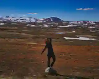 Im Hintergrund die noch leicht schneebedekten Hügel vom Vildmarksvägen im Vorergund ein paar Grasshalme und Jo.