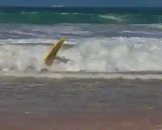 Waves and a lonesome Surfboard beaing tossed by the waves