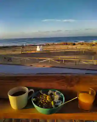 Jos Frühstück während des Camps. Kaffee, O-Saft und Müsli mit blick auf den Strand