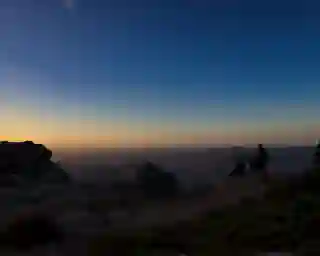 Sunrise on Mont Caroux, showing the hilly surroundings and part of the Mont Caroux rock plateau where Jo, Georg, and Momo wait for the sun