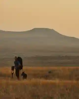 Georg mit einem Großen Backpack auf dem Rücken in den Grasslands.