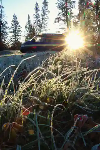 Our T4, the "Quest" standing on frozen grass. In the background, the sun is rising lighting up the ice crystals.