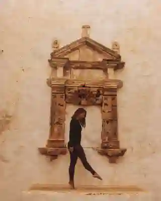 Jo on a ledge. In the background, half columns.