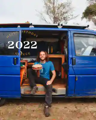 Georg sits in the open sliding door with his birthday cake.