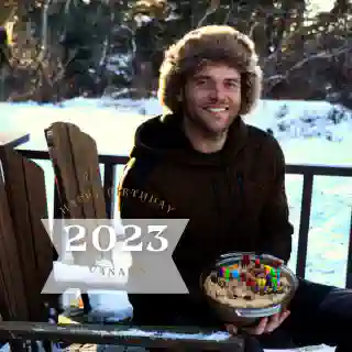 Georg with his fur hat on the Tiny House porch with one of his birthday cakes.
