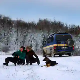 George, Jo, Momo, and Nelly in the snow, with the Quest visible in the background.