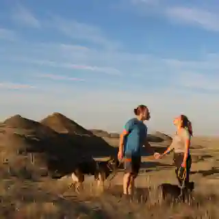 Die Prärie in Kanada! Eine unvergässliche Landschaft. Im Hintergrund wölben sich die Hügel empor, im vordergrund stehen Jo, Georg, Momo und Nelly