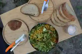 Its ready! Overhead view of our set table.There is a candle, two plates, cutlery, fresh bread, and a bowl of salad and Moroccan chickpeas .