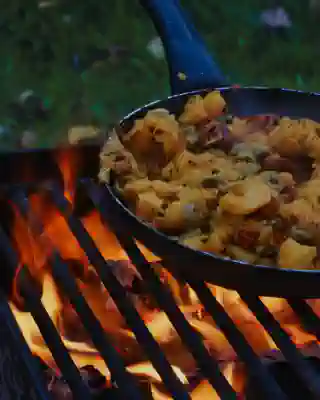 Eine Pfanne mit Kürbis steht auf einem Grillrost.