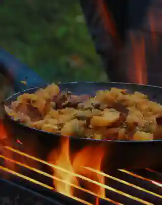 Eine Pfanne mit Kürbis steht auf einem Grillrost. Die Flammen züngeln heraus