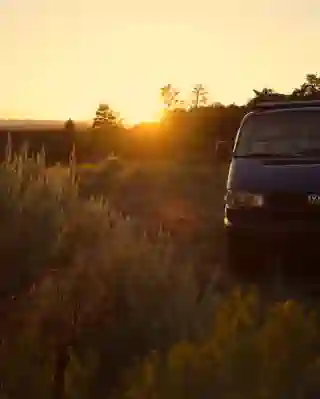 Front of the T4, in the background the sun is just setting behind the mountains.